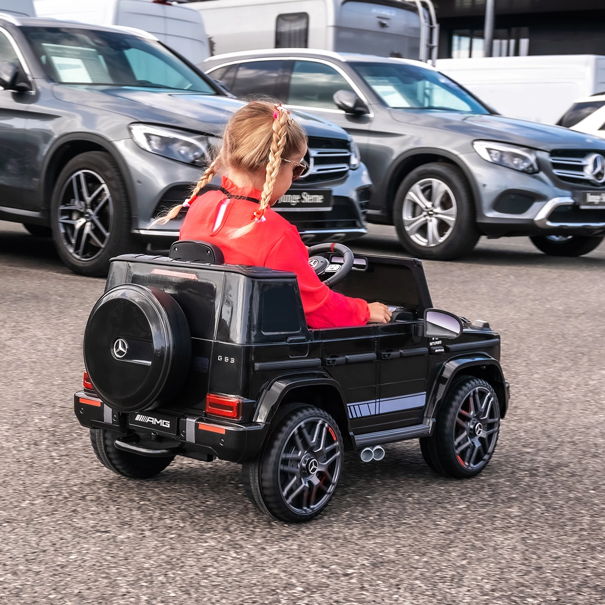 Zwei starke Motoren mit je 35 Watt Mädchen fährt mit dem Kinder-Elektroauto über einen Parkplatz
